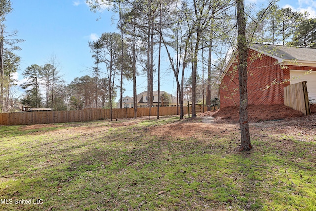 view of yard with fence and a garage