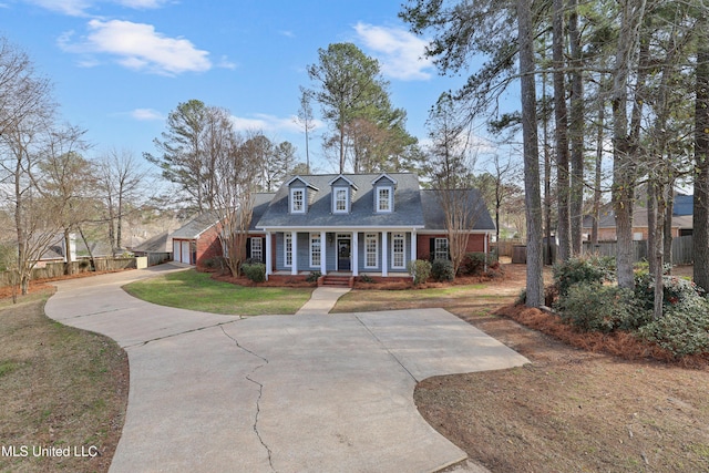 view of front facade featuring a front lawn, a porch, fence, concrete driveway, and a shingled roof