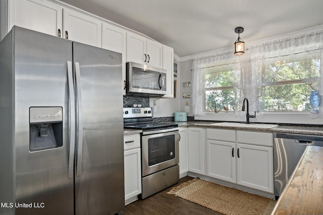 kitchen featuring white cabinetry, stainless steel appliances, sink, and pendant lighting