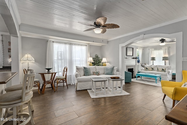 living room featuring dark wood-type flooring, ceiling fan, wooden ceiling, and a wealth of natural light