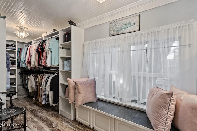 spacious closet featuring dark wood-type flooring and a notable chandelier