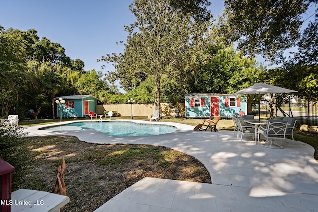 view of pool featuring a patio and a shed