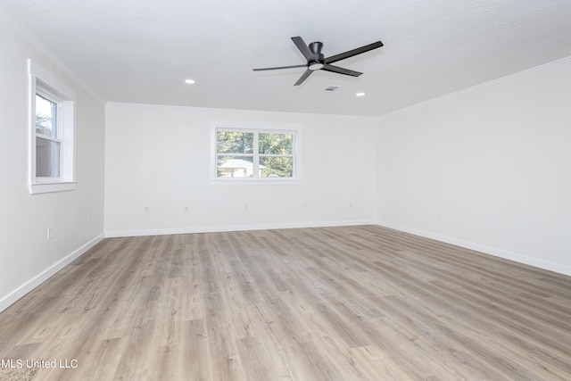 spare room featuring crown molding, light hardwood / wood-style flooring, and plenty of natural light