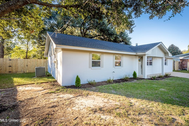 ranch-style home featuring central air condition unit and a front lawn