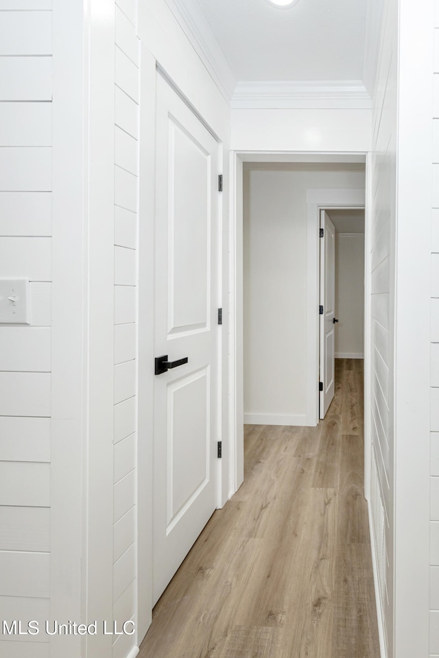 hall with light hardwood / wood-style floors and ornamental molding