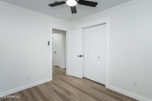 unfurnished bedroom with a closet, ceiling fan, ornamental molding, and light wood-type flooring