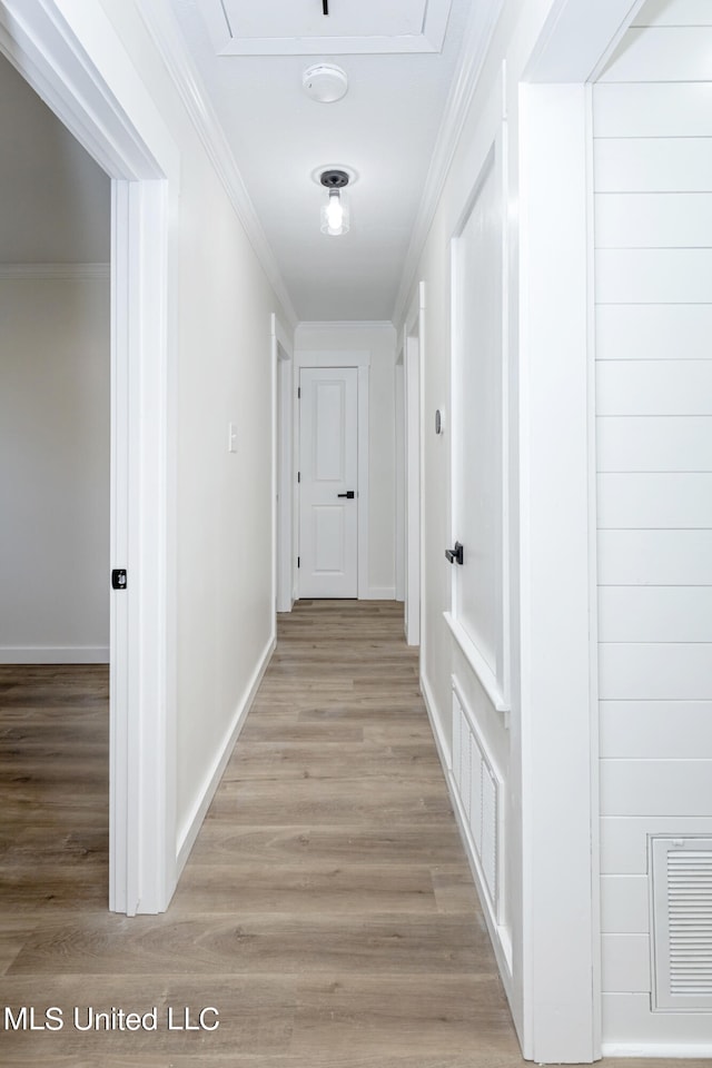 corridor with crown molding and light hardwood / wood-style flooring