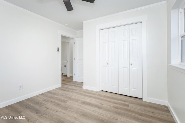 unfurnished bedroom featuring crown molding, light hardwood / wood-style flooring, a closet, and ceiling fan