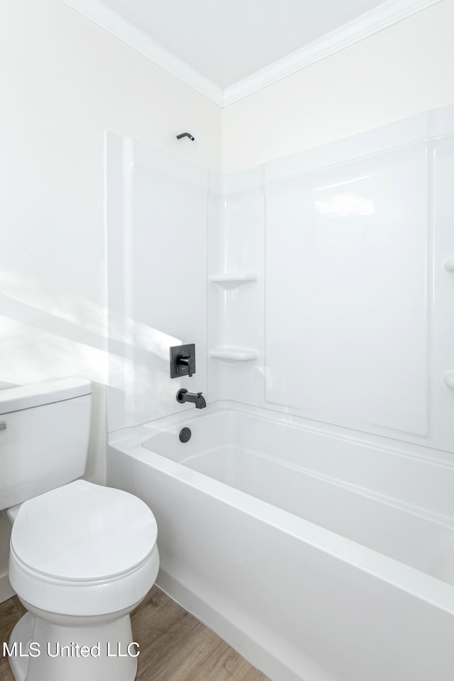 bathroom featuring ornamental molding, wood-type flooring, shower / bathing tub combination, and toilet