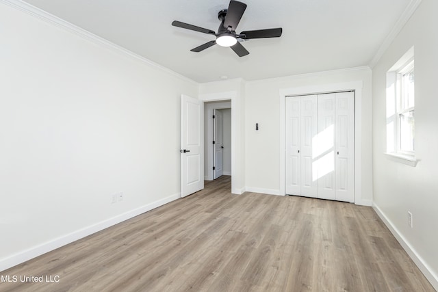 unfurnished bedroom with a closet, crown molding, light hardwood / wood-style floors, and ceiling fan