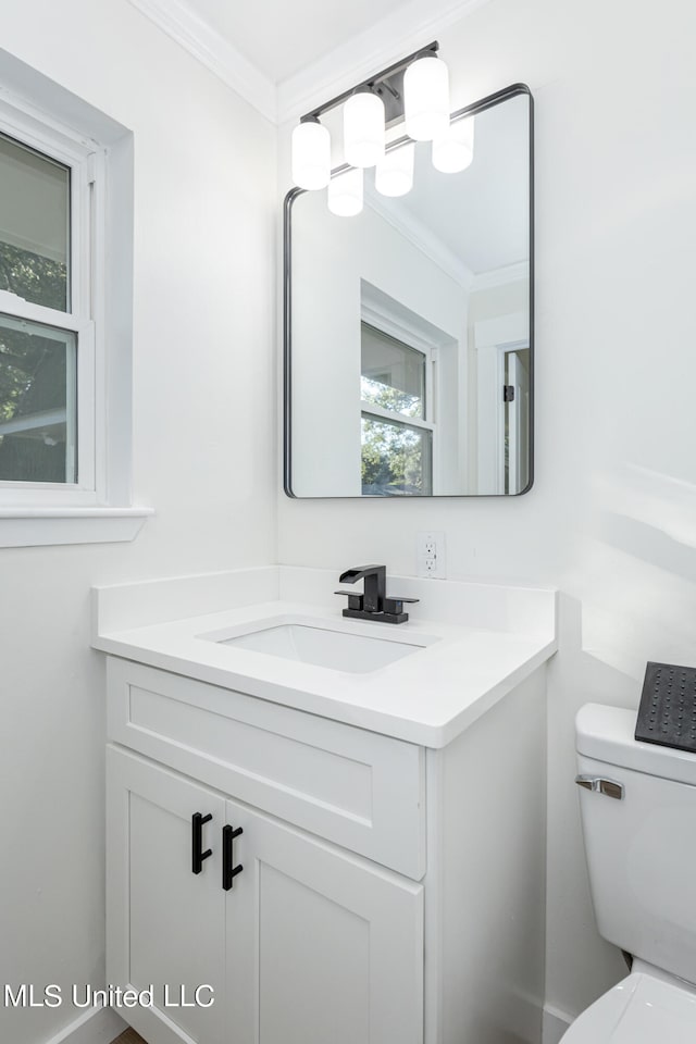 bathroom featuring vanity, crown molding, and toilet