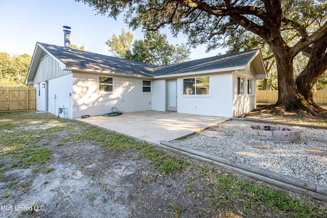 back of property with a patio and a fire pit