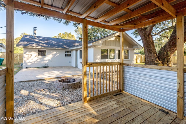 wooden deck featuring a patio area and a fire pit