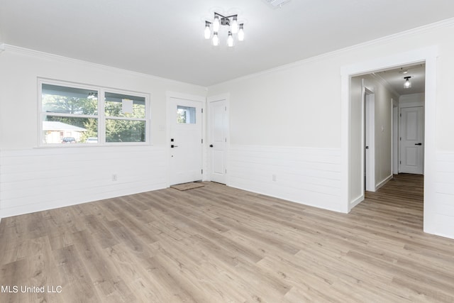 spare room with light hardwood / wood-style floors and crown molding