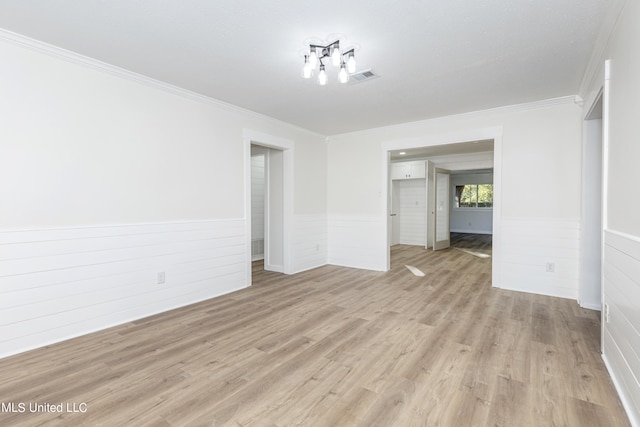 spare room featuring crown molding and light wood-type flooring