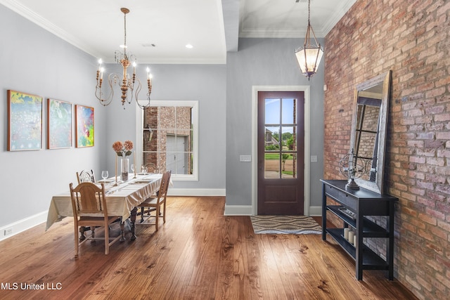 dining area featuring crown molding, baseboards, hardwood / wood-style floors, and a chandelier