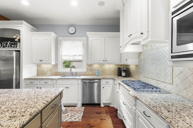 kitchen with backsplash, white cabinetry, appliances with stainless steel finishes, and a sink