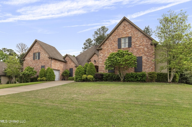 view of front facade featuring brick siding, a front yard, and concrete driveway