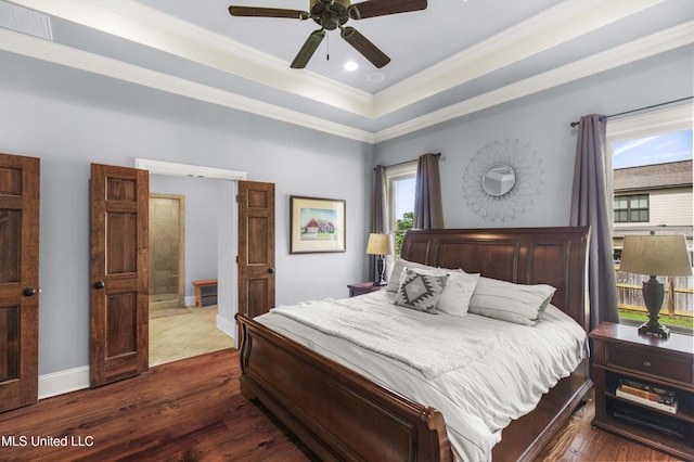 bedroom featuring ceiling fan, dark wood-style flooring, visible vents, crown molding, and a tray ceiling