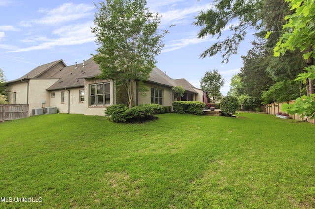 view of yard with a fenced backyard and central AC unit