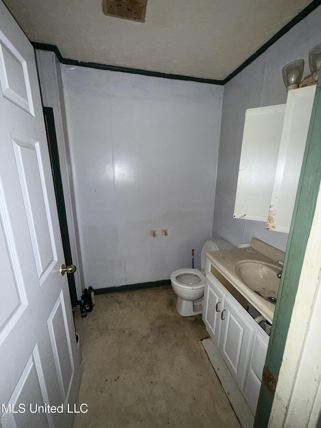 bathroom featuring concrete flooring, vanity, and toilet