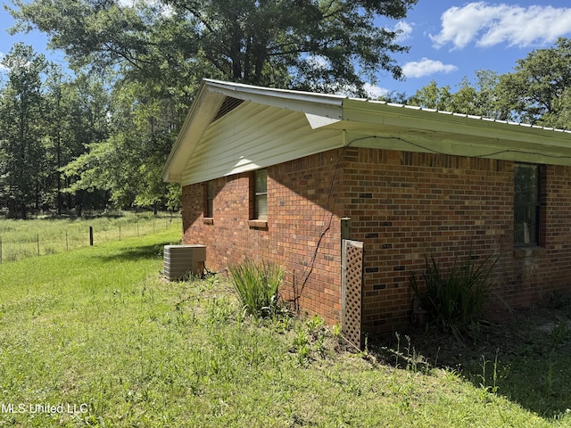view of property exterior with brick siding and central AC unit