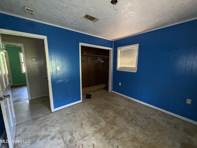 unfurnished bedroom featuring a textured ceiling, a closet, baseboards, and concrete floors