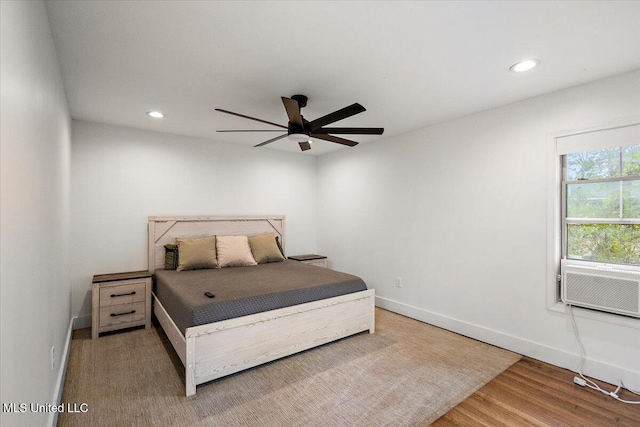 bedroom with hardwood / wood-style floors, ceiling fan, and cooling unit