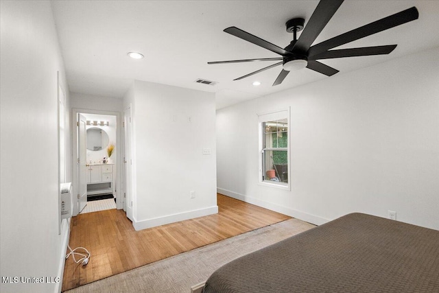 unfurnished bedroom with ceiling fan, wood-type flooring, and connected bathroom