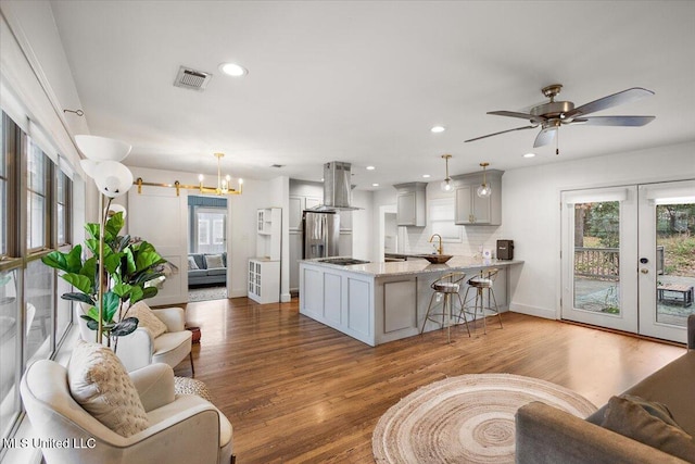 living room featuring french doors, sink, hardwood / wood-style flooring, ceiling fan, and a barn door