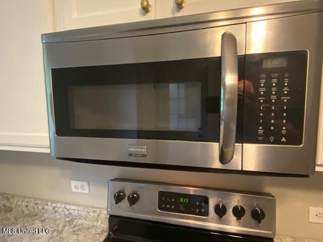 details with white cabinetry and appliances with stainless steel finishes