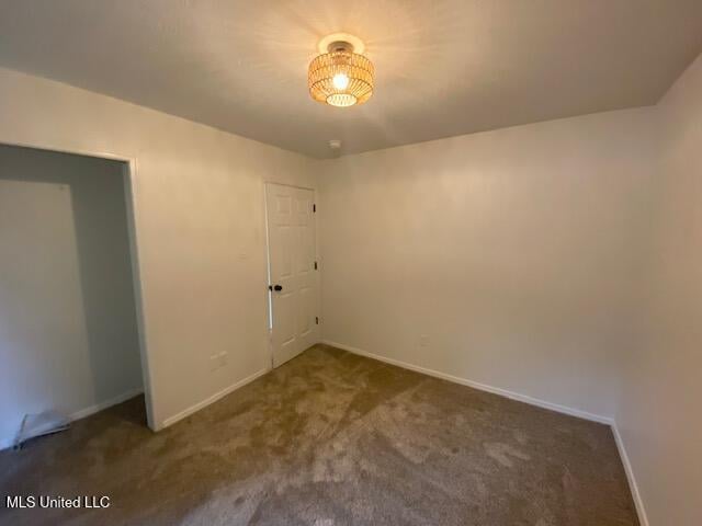 carpeted spare room featuring baseboards
