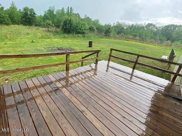 wooden deck with a rural view and a yard