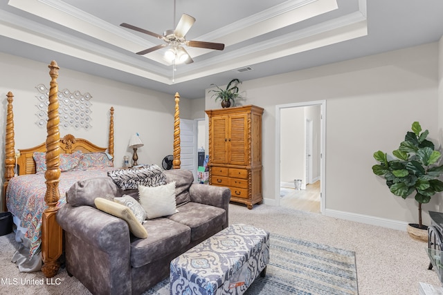 carpeted bedroom with ceiling fan, crown molding, and a tray ceiling