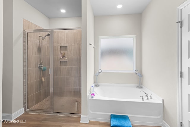 bathroom featuring wood-type flooring and separate shower and tub