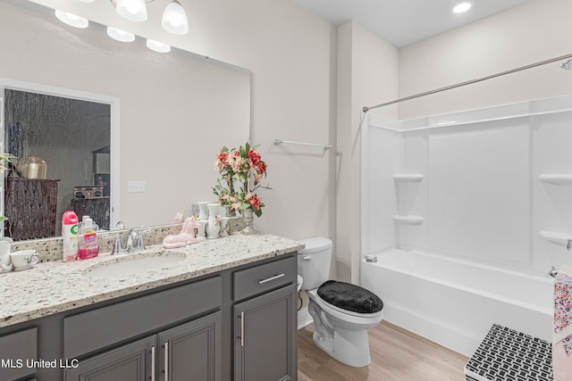 full bathroom featuring toilet, shower / washtub combination, hardwood / wood-style flooring, and vanity