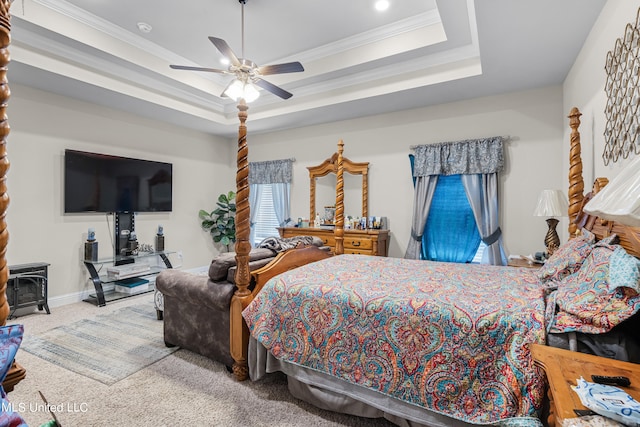 carpeted bedroom with ceiling fan, a raised ceiling, and ornamental molding