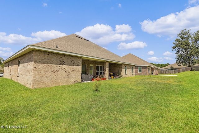 back of house featuring a patio area and a lawn