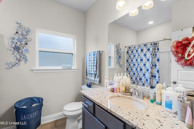 bathroom with vanity, toilet, and hardwood / wood-style floors