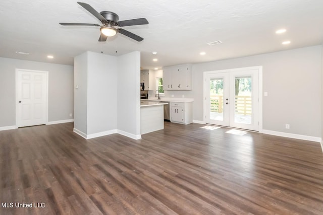 unfurnished living room featuring baseboards, visible vents, dark wood-type flooring, french doors, and a sink