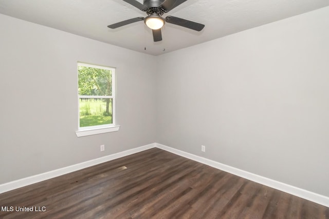 unfurnished room featuring baseboards and dark wood-type flooring