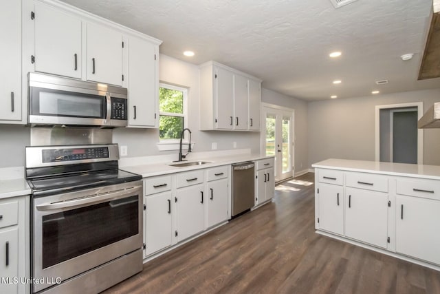 kitchen with dark wood-style floors, recessed lighting, light countertops, appliances with stainless steel finishes, and a sink