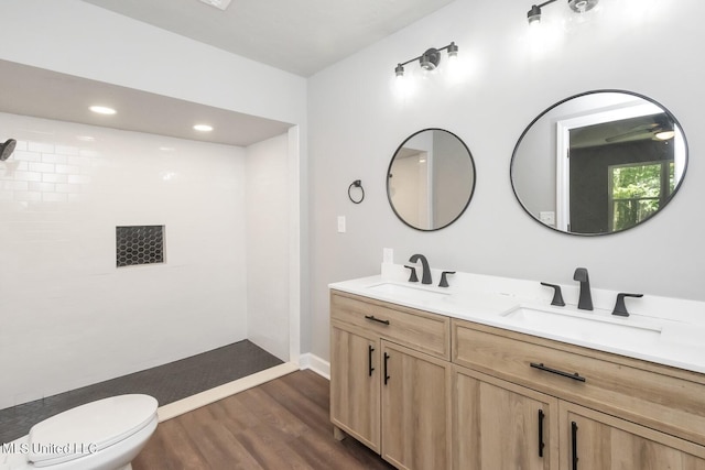 full bathroom with double vanity, wood finished floors, a sink, and toilet