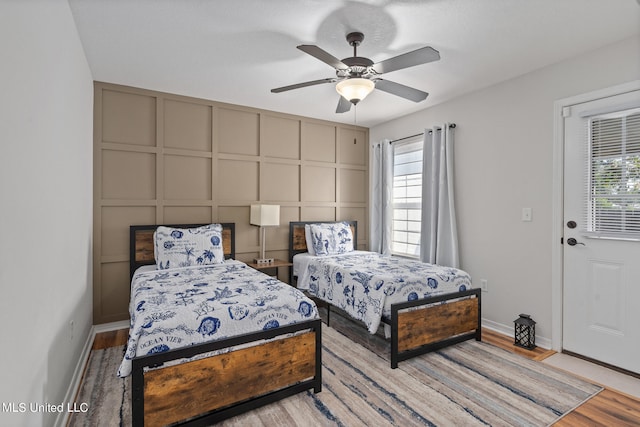 bedroom featuring ceiling fan, light hardwood / wood-style floors, and multiple windows