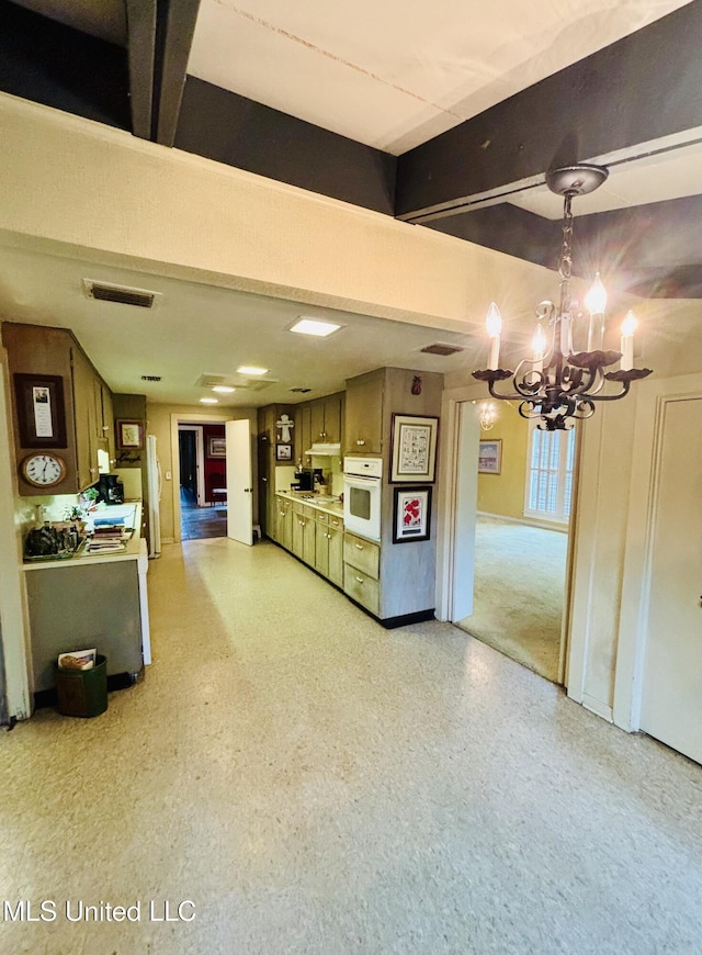 kitchen with an inviting chandelier, visible vents, light countertops, and white oven