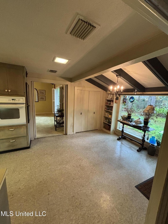 basement with visible vents, an inviting chandelier, and a textured ceiling