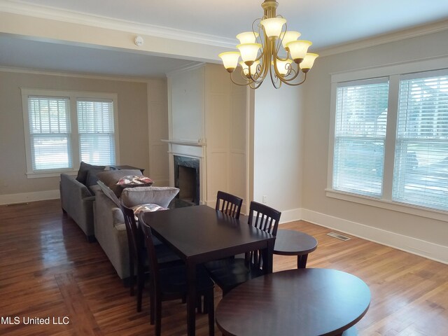 107 E Percy St, Indianola, MS 38751 - dining space featuring healthy amount of natural light, a chandelier, baseboards, a fireplace, and ornamental molding
