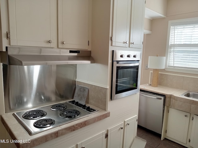 107 E Percy St, Indianola, MS 38751 - kitchen featuring stainless steel appliances, under cabinet range hood, light countertops, and white cabinets