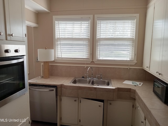 107 E Percy St, Indianola, MS 38751 - kitchen with appliances with stainless steel finishes, a sink, white cabinets, and tile counters