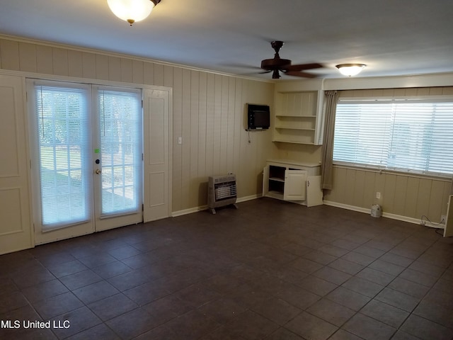 107 E Percy St, Indianola, MS 38751 - unfurnished living room with heating unit, ceiling fan, baseboards, dark tile patterned floors, and french doors